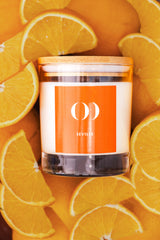 Candle with an orange label on a background of sliced oranges